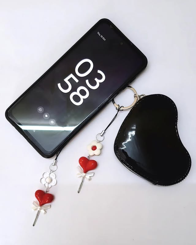 Phone charm styled with a phone and earbuds